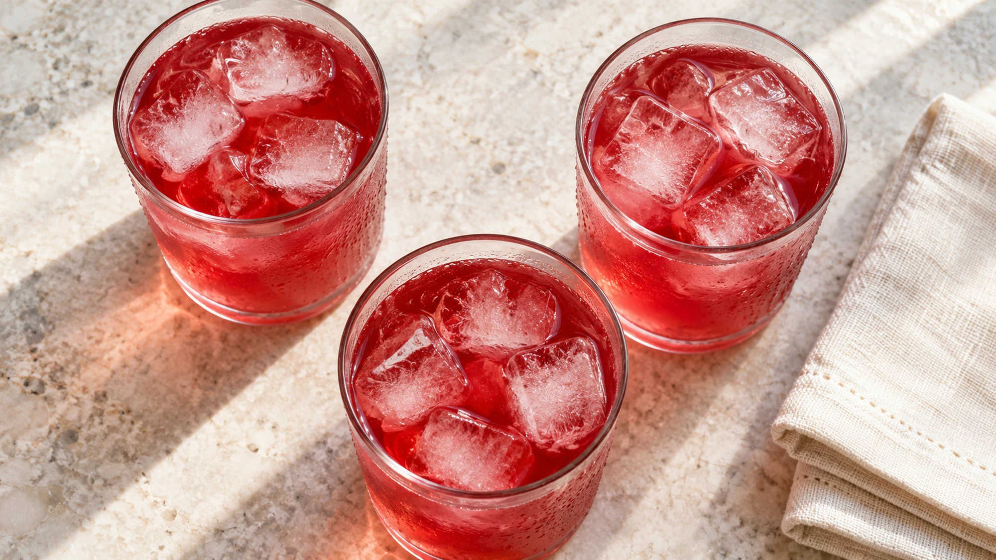 Cranberry lemonade in three ice-filled glasses viewed from above