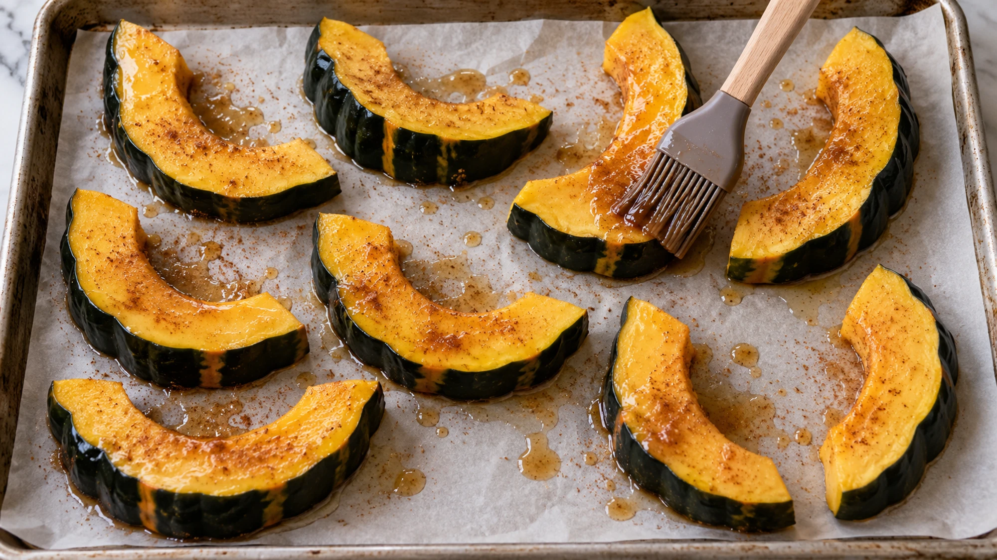 Brushing maple roasted acorn squash wedges with a thin glaze