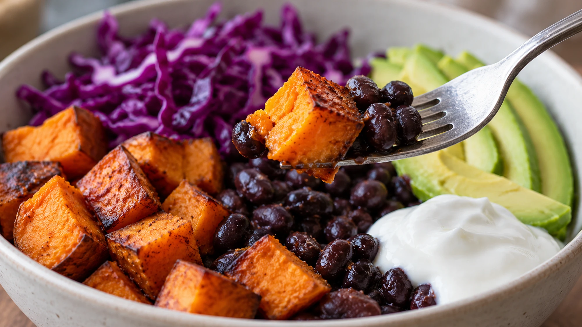 Forkful of roasted potato and beans from sweet potato black bean bowls