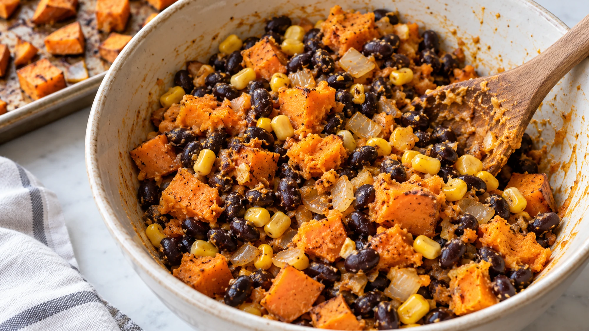 Sweet potato enchiladas filling with black beans, corn, and onion